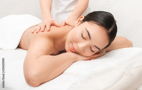 Anti-stress Thai massage. A beautiful Asian woman is getting a back massage at a Thai spa resort