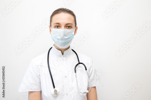 Nice young girl doctor in uniform, medical mask and stethoscope.