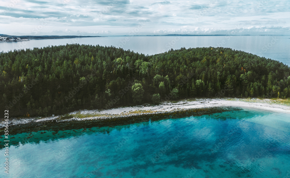 Aerial view ocean and uninhabited island with coniferous forest drone nature landscape travel in Norway turquoise sea water scandinavian nature beautiful destinations scenery