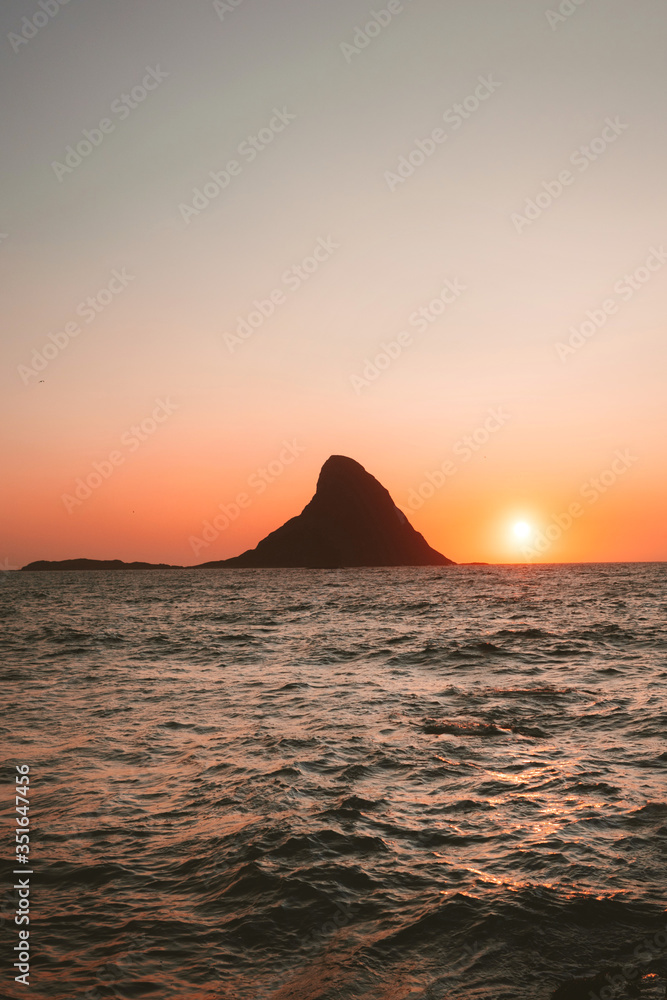 Sunset ocean and island Bleiksoya rock landscape in Norway summer travel vacations nature scenery Vesteralen islands.