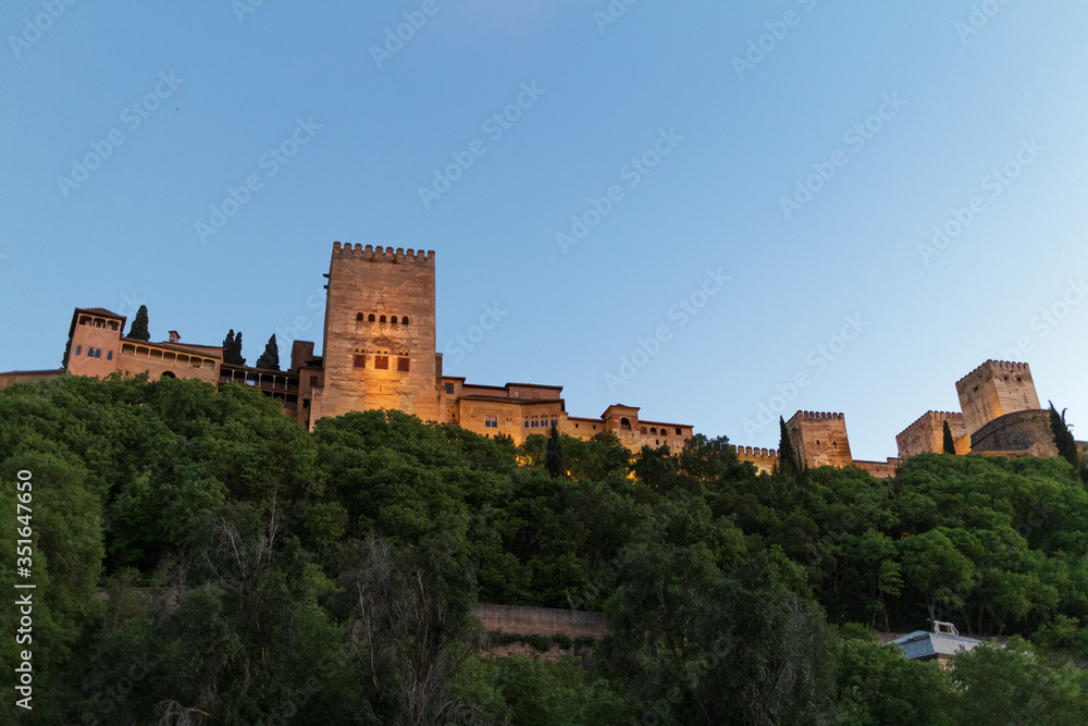La Alhambra de Granada iluminada de noche con cielo azul