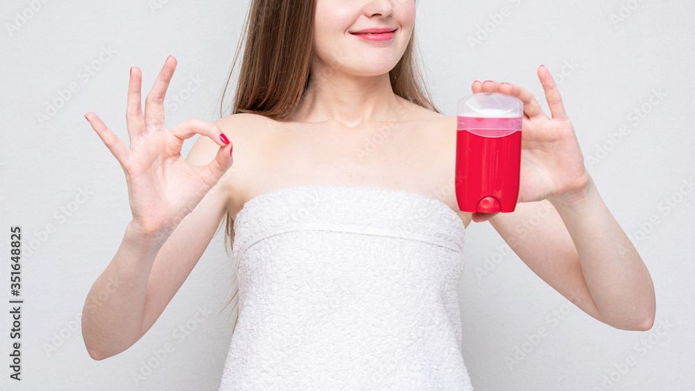 Half naked woman with deodorant, girl shows gesture okay, portrait, white background, copy space, 16:9 Half naked woman with deodorant, girl shows gesture okay, portrait, white background, copy space, 16:9