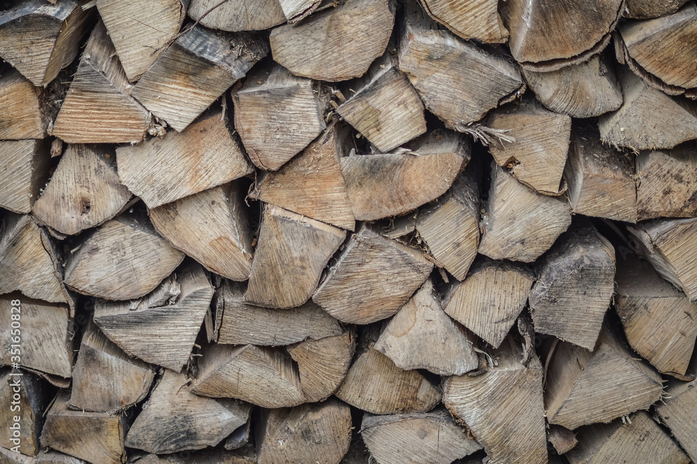 Fototapeta premium Background of dry firewood - stack of wood