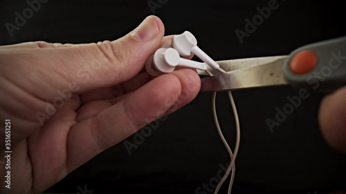 Hands holding the scissors to cut the headphone photo