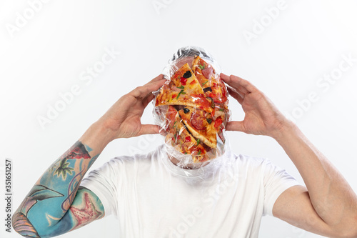 Male face covered with oilcloth, cellophane and unhealthy food, hard to breathe. People lost their faces, can't notice the environmental pollution made by themself. Garbage, problem, breathing. photo