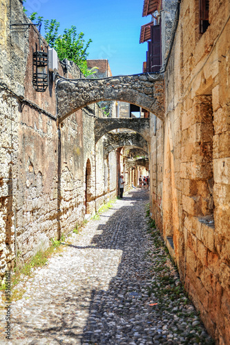 In the narrow streets of medieval Rhodes  there are two-story houses of merchants and artisans  connected by arches and passages. This ensures the stability of buildings in case of an earthquake.   