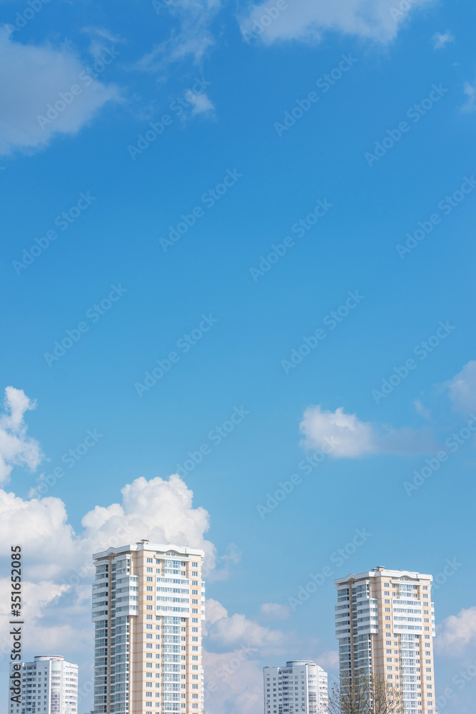Apartment buildings, blue sky with clouds, vertical, copy space