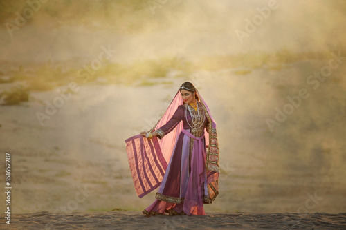 portrait of beautiful Arabian girls in traditional suit with valuable accessory, Persian girls in desert