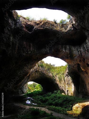 View on the openings of the karst cave Devetashka, the inner river and the main entrance into the cave, Bulgaria