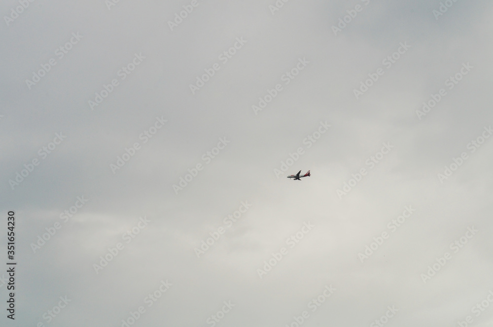 Airplane flying in a cloudy sky