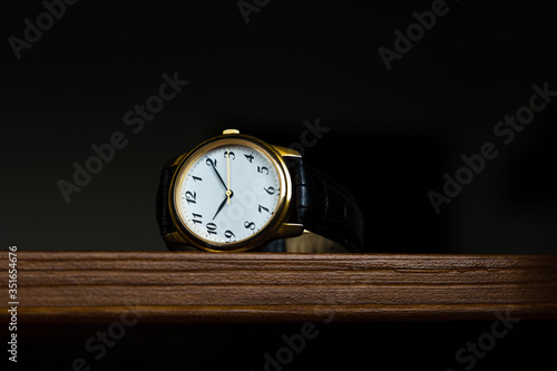 Wallpaper Mural Retro golden wristwatch with Roman numerals on the dial lie on a wood surface. Torontodigital.ca