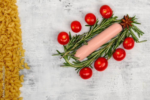 The sausage lies surrounded by cherry tomatoes