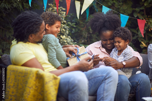 Afro-American family enjoying together outdoor at birthday party.