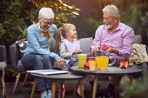 Cheerful girl spending good time with her grandparents.