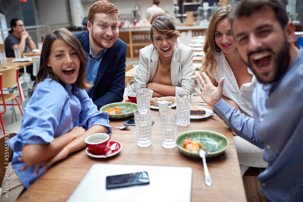 group of young caucasian adults having fun at lunch in restaurant, taking selfie
