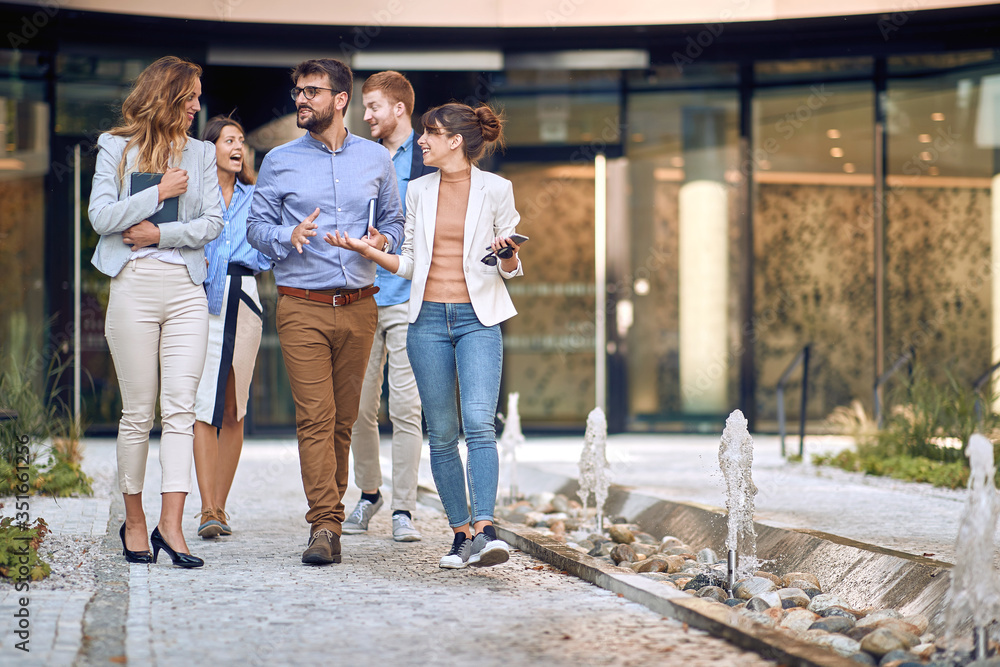 Fototapeta premium group of young businesspeople walking out of the building to have a break.