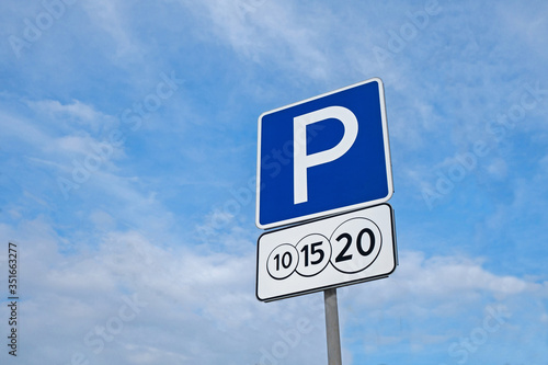 Combination of international traffic signs 'Parking' & 'Payment service'. Cloudy sky is on background