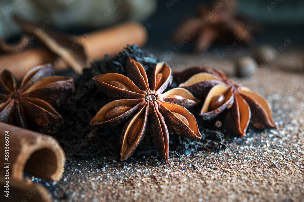 Anise stars with spices and black tea on a blue background. Recipe for tea masala. Anise stars with spices and black tea on a blue background. Recipe for tea masala.