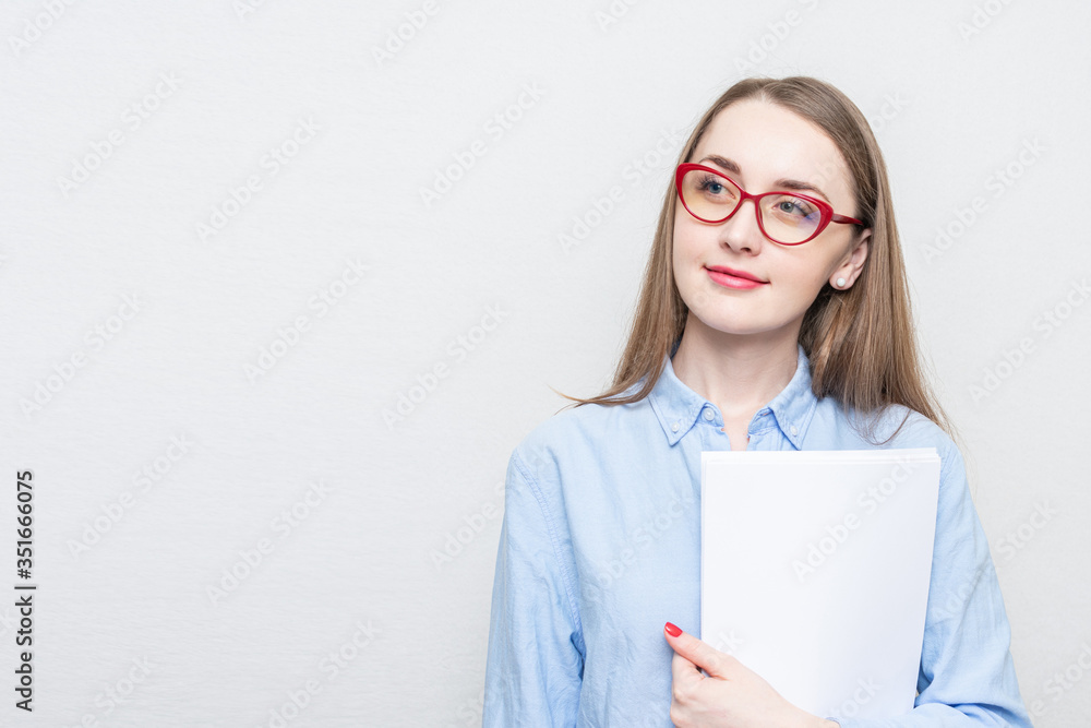 Beautiful student in red glasses looks thoughtfully to the side, portrait, white background, copy space Beautiful student in red glasses looks thoughtfully to the side, portrait, white background, copy space