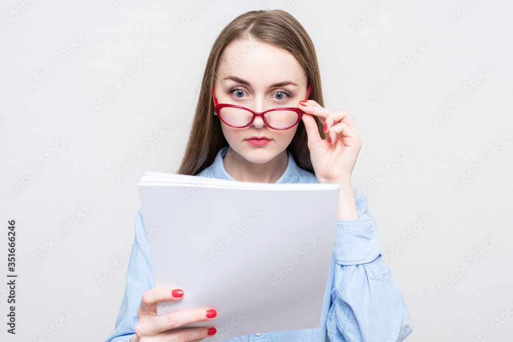 Teacher woman reads the essays of her students and takes off her glasses, portrait, white background