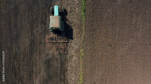 top view, aerial view. the tractor cultivates the land. preparation for growing crops. agriculture in the village and in the countryside.