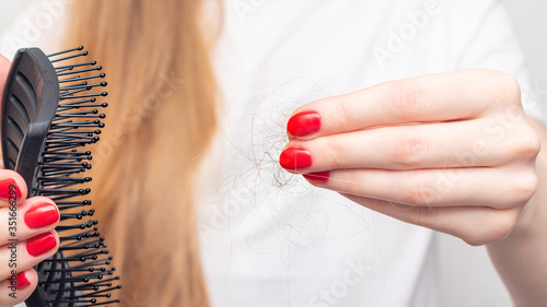 Concept of hair loss. Women's hands with a comb and hair, close up, 16:9