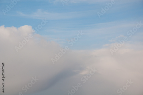 Puffy white clouds with wispy blue sky in this nature shot. Weather and meteorology concepts that also make good backgrounds. © Valerie Garner