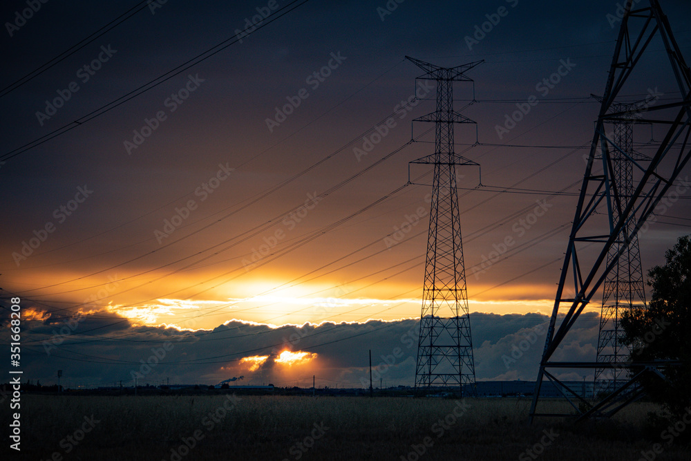 sunset landscape with high voltage electricity pylons