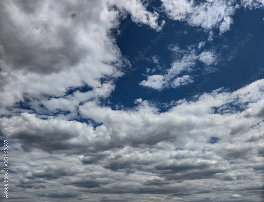 Low dark blue and blue sky with thunderous white-dark feather clouds Low dark blue and blue sky with thunderous white-dark feather clouds