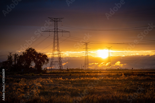 sunset landscape with high voltage electricity pylons