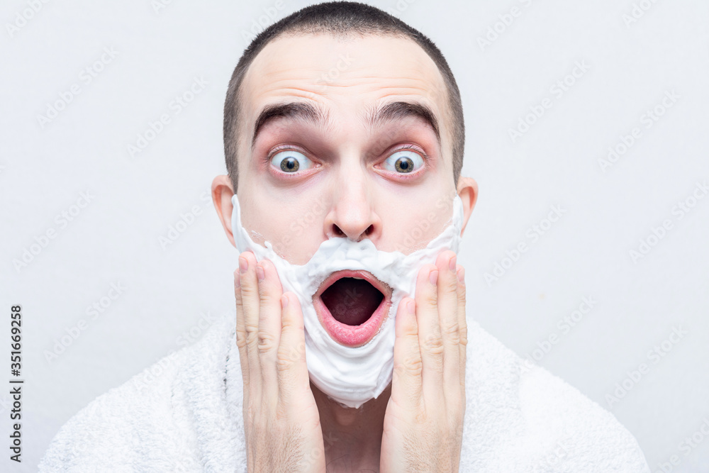 Funny man with shaving foam on his face, guy shouts: wow! Portrait, white background Funny man with shaving foam on his face, guy shouts: wow! Portrait, white background