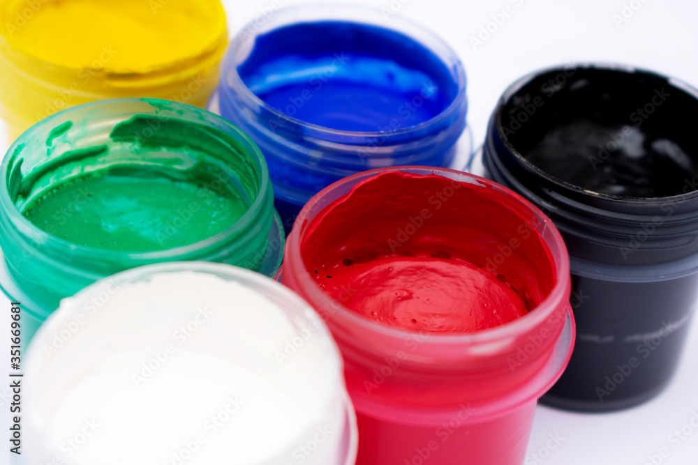 Cans of different colors gouache paints, top view, white background, closeup Cans of different colors gouache paints, top view, white background, closeup