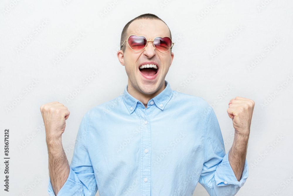 Naklejka premium In love man rejoices in victory or good news, guy with heart-shaped glasses, white background