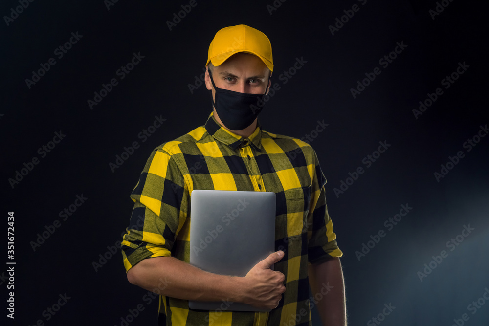Fototapeta premium portrait of a construction worker in mask on black background