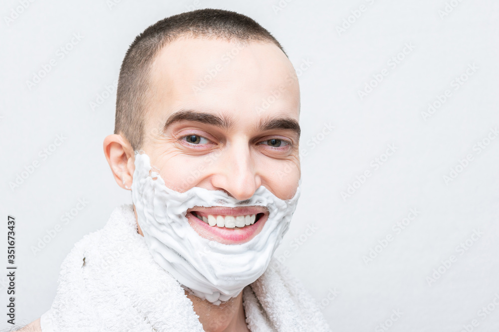 Handsome man with shaving foam on his face, white background, copy space Handsome man with shaving foam on his face, white background, copy space