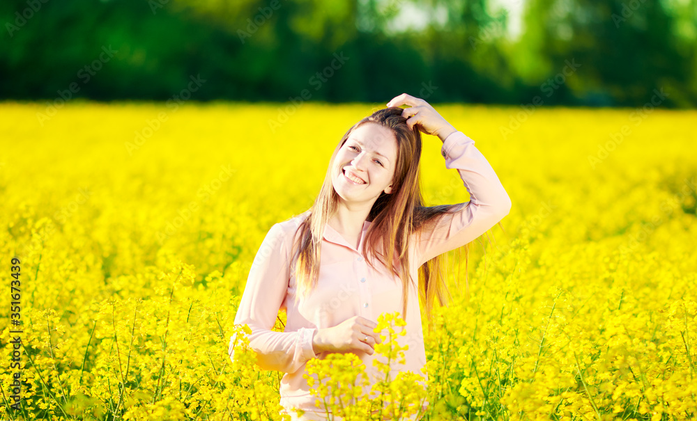 Girl in a blooming rapeseed field, cheerful happiness Girl in a blooming rapeseed field, cheerful happiness