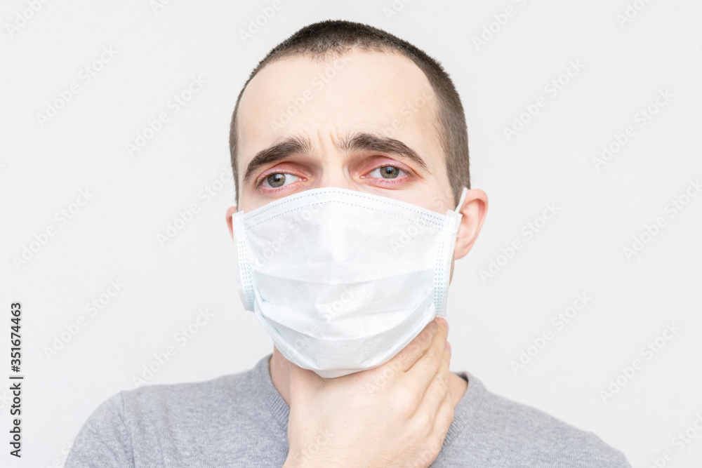 Man in a medical mask has a sore throat, a guy has the flu, portrait, closeup