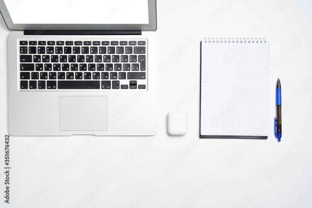 work space with a laptop, Notepad with pen and wireless headphones on a white background. The view from the top. Flat style. work space with a laptop, Notepad with pen and wireless headphones on a white background. The view from the top. Flat style.