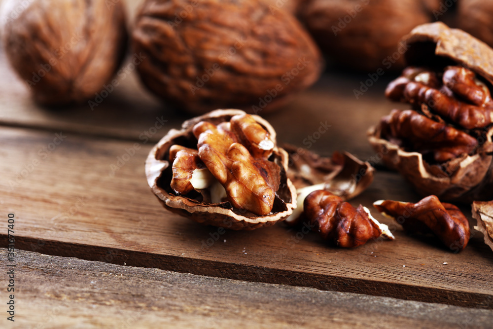 Walnut kernels and group of whole walnuts on rustic old table Walnut kernels and group of whole walnuts on rustic old table