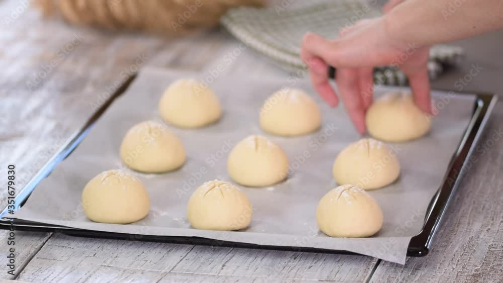Woman makes homemade breakfast buns. Making buns. Dough on a baking tray. Woman makes homemade breakfast buns. Making buns. Dough on a baking tray.