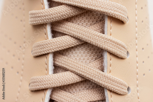 Lace on beige sneakers, close up