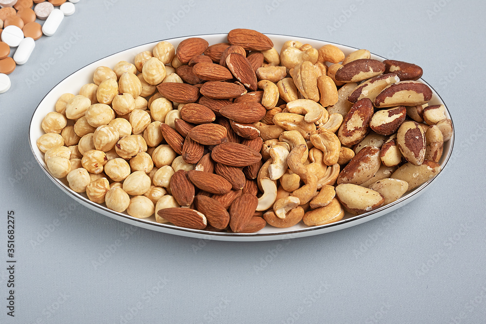 Four kinds of roasted nuts on plate. Healthy fats for health Four kinds of roasted nuts on plate. Healthy fats for health