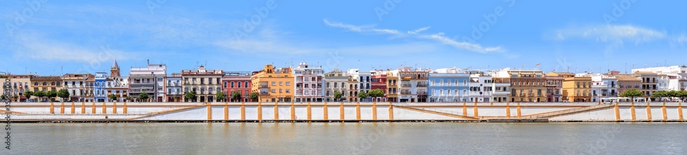 Colorful houses of Triana neighborhood (Betis street) on the River Guadalquivir near the Triana bridge in Seville, Spain.
