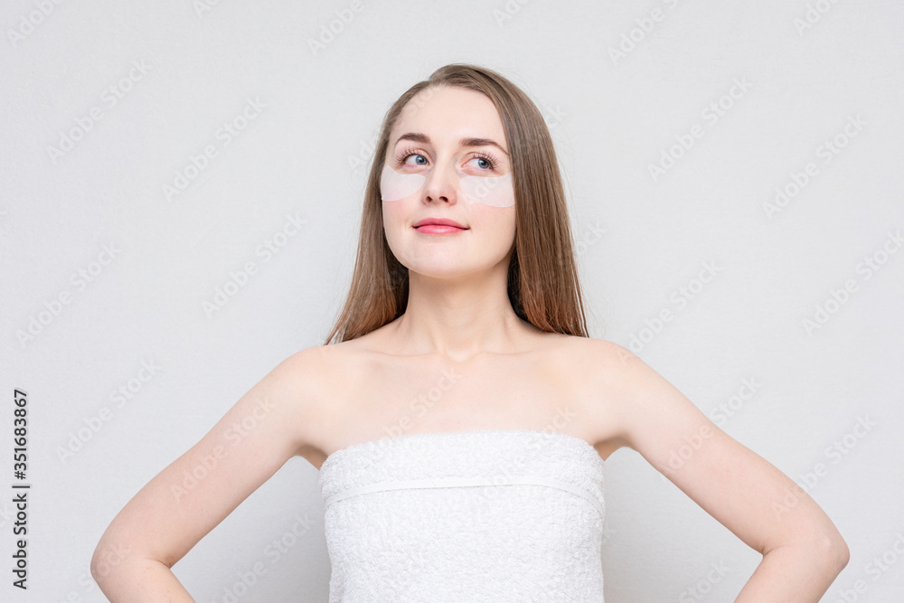 Pretty girl using white under eye patches, white background. Concept of eye skin treatment Pretty girl using white under eye patches, white background. Concept of eye skin treatment