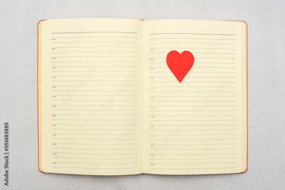 Notebook with red heart, white background, top view, copy space Notebook with red heart, white background, top view, copy space