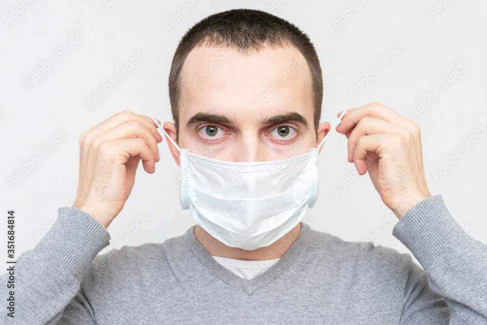 Person wears a medical mask, white background, portrait, closeup Person wears a medical mask, white background, portrait, closeup
