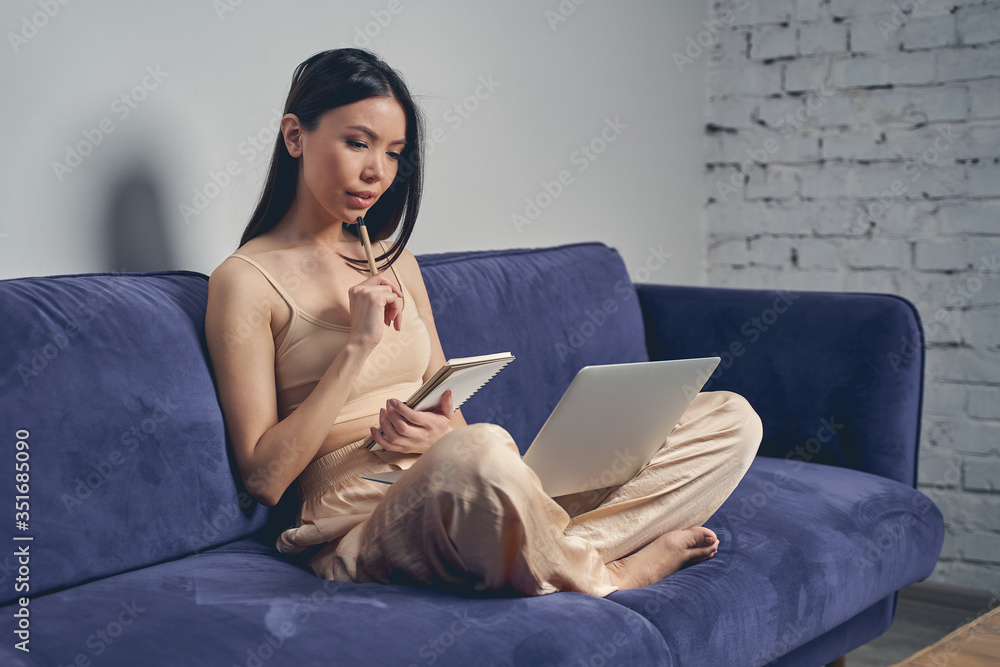 Beautiful lady using modern notebook and making notes Beautiful lady using modern notebook and making notes