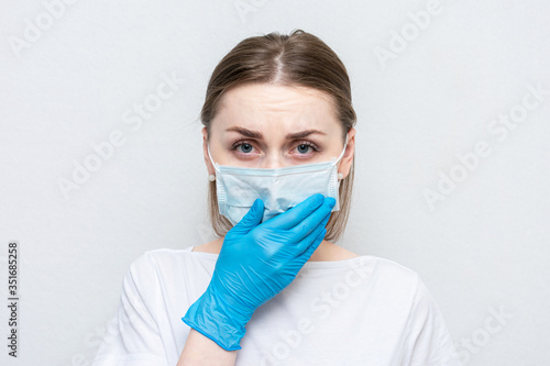 Health doctor woman in a medical mask is ill, girl sneezes, white background