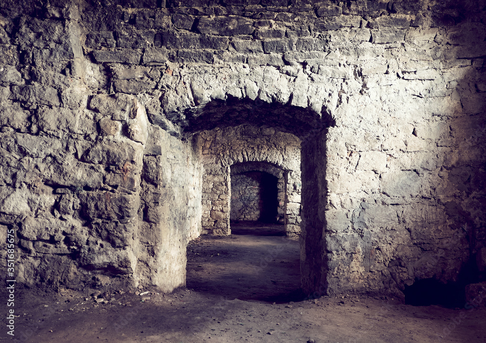 Basement tunnel of the old castle. The stone walls of the prison. A long corridor through several rooms. Earthen floor.