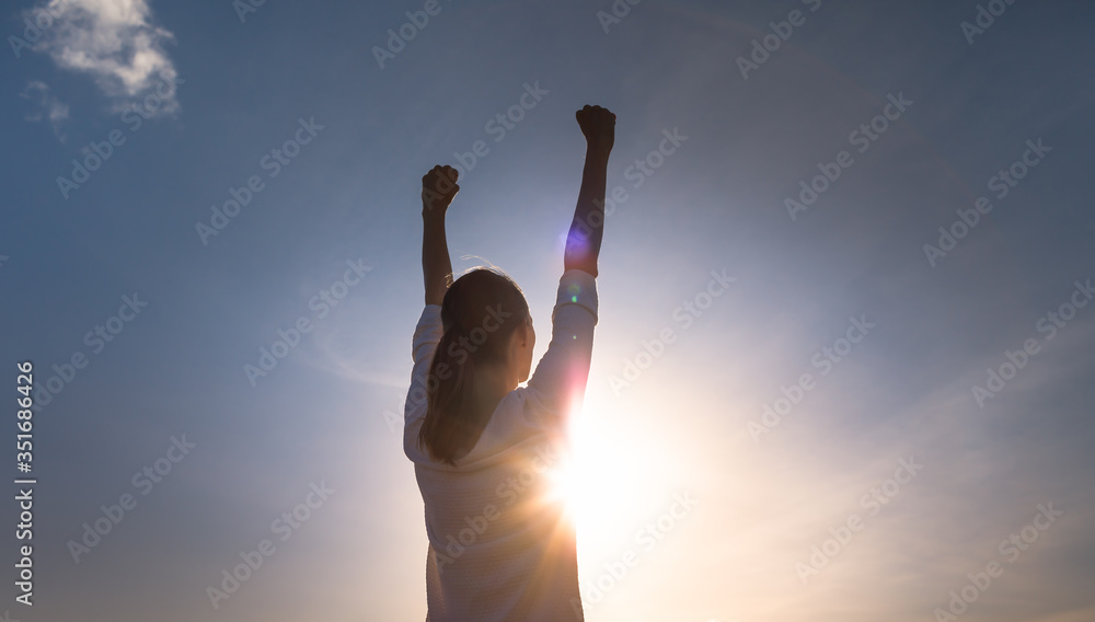 silhouette of a strong confident woman with fist in the sky. Girl power concept. 